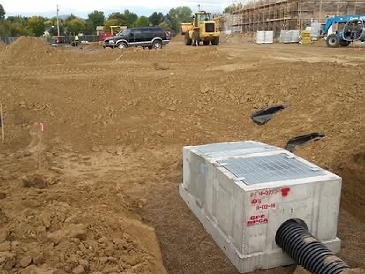Concrete storm-drain box structure and corrugated pipe set in a trench