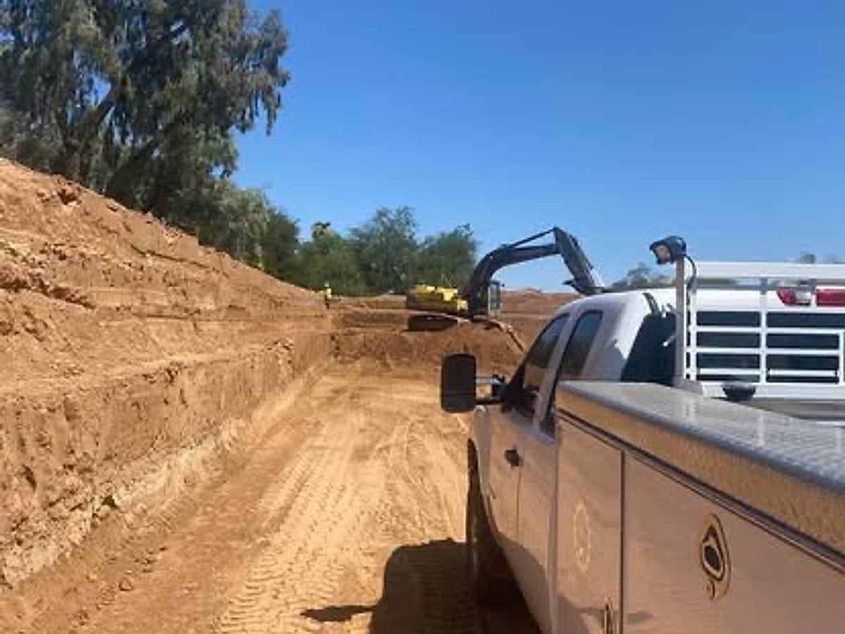 Excavator loading dump trucks with excavated soil